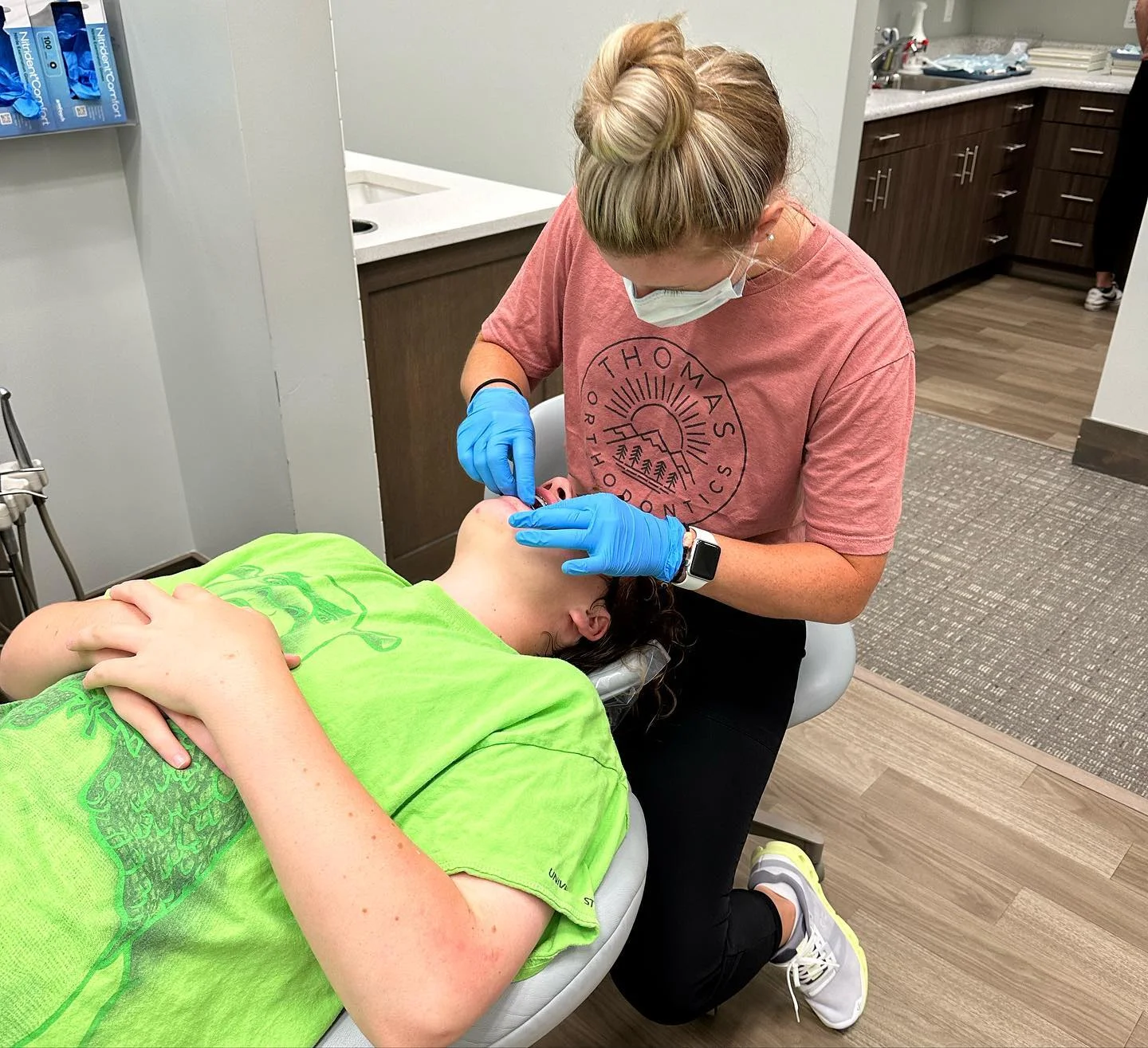 Orthodontist performing procedure on patient in the clinic.